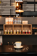A cup of fresh coffee in coffee shop with blurred background