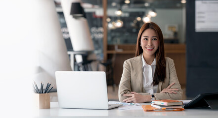 Confident and Attractive Businesswoman Smiling At Camera Sitting In Modern Office.