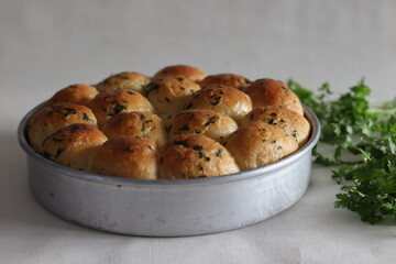 Dinner rolls. Home baked golden brown color dinner rolls fresh from the oven, glazed with butter inside circular bake tin.
