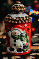 Christmas lantern with a snowman figurine against the background of multi-colored Christmas tree lights. Christmas decorations. bokeh. Christmas and New Year