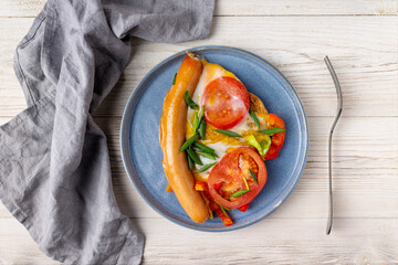 a piece of scrambled eggs on a blue plate, fork, cotton napkin, copy space