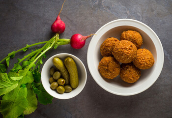 Falafel with pickle, olives and red radish. Authentic Mediterranean or Arabic cuisine.