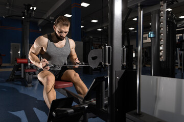 Obraz na płótnie Canvas man doing arm exercises on the simulator in the gym
