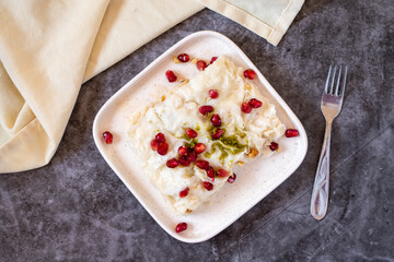 Gullac dessert on dark background. Traditional Ramadan dessert. Güllaç dessert decorated with...