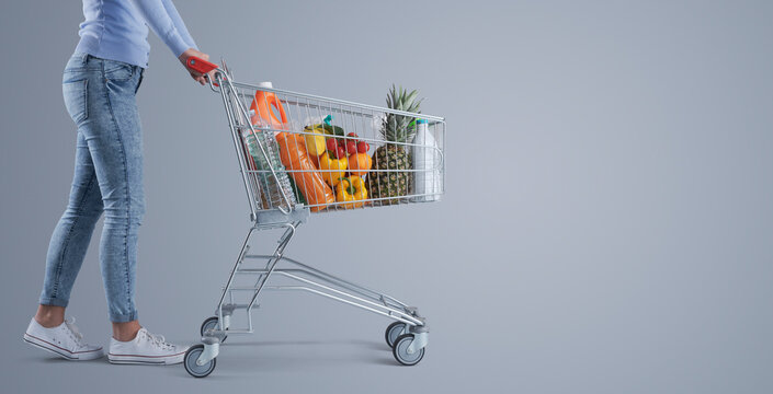 Woman Pushing A Full Shopping Cart