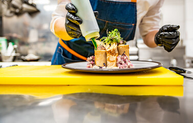 chef cooking food. Chef's hands in gloves cooking fried thin pancakes crepe stuffed potato with herring fish on kitchen