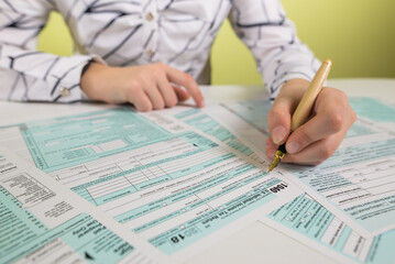 female hand filling us tax form, 1040.