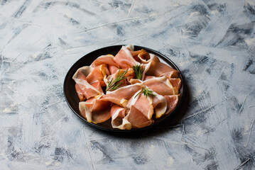 Prosciutto crudo, Italian salami, parma ham. Antipasto plate. Gray background, top view. Copy space
