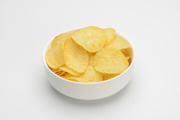 Patatas fritas o chips en un bol de cerámica blanca sobre fondo blanco - obrazy, fototapety, plakaty