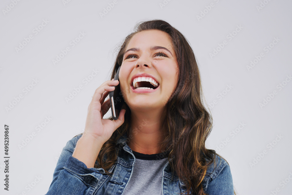 Sticker You crack me up every time you call. Studio shot of a young woman using a mobile phone against a grey background.