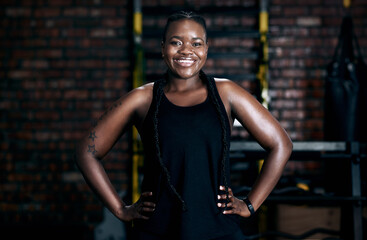 The gym is my playground. Cropped portrait of an attractive young female athlete standing with her hands on her hips in the gym.