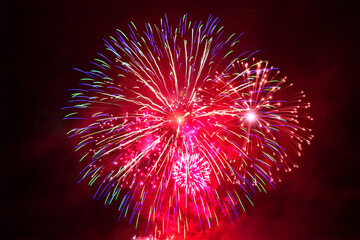 Red fireworks in the night sky at New Year's Eve celebration 
