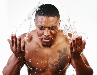 Was drowning, but now Im swimming. Studio shot of a handsome young man splashing water on his face against a white background.
