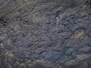 Lava field from above. Cooled lava flow with structures in dark color. Patterns of deflected and...