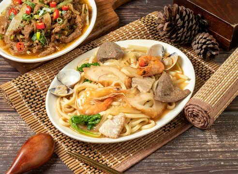assorted fried noodles in a dish isolated on mat side view on dark wooden table taiwan food