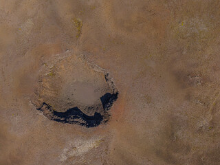 Old crater from above in sunshine. View into an extinct crater on Iceland Rekjaney Peninsula. landscape of brown sand around the crater. Shadows cast by craters
