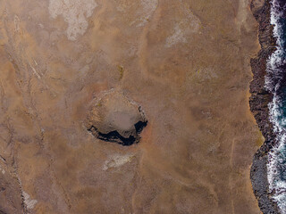 Top view on landscape of Iceland. Old crater on brown sand surface on coast of Reykjanes Peninsula....