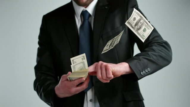 Super slow motion of businessman throwing dollar banknotes. Filmed on high speed cinema camera, 1000 fps.