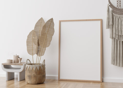 Empty vertical picture frame standing on parquet floor in modern living room. Mock up interior in scandinavian, boho style. Free space for picture. Macrame, rattan basket. 3D rendering.