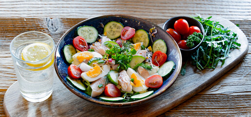 A plate of vegetable salad with trout and eggs