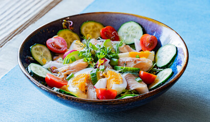 A plate of vegetable salad with trout and eggs