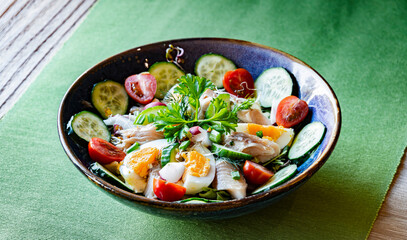 A plate of vegetable salad with trout and eggs
