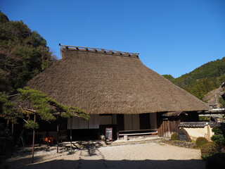 青空と伝統的なかやぶきの日本家屋