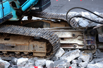 Rock excavator working to demolish concrete.