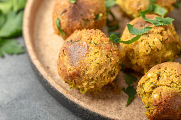 Chickpea falafel with lime and sauce on a plate and grey table close up