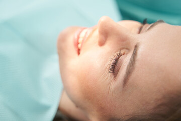 Obraz na płótnie Canvas Joyful woman resting after procedure in stomatology clinic