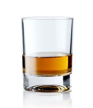 Scotch whiskey in an elegant glass on a white background with reflections.