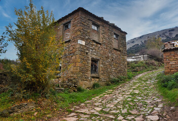 Fototapeta na wymiar Abandoned, weathered stone house in a mountain town in Gökçeada. Tepeköy village