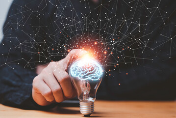 Businessman hand touching lightbulb with glowing virtual brain and  connection line to creative smart thinking for inspiration and innovation with network concept.