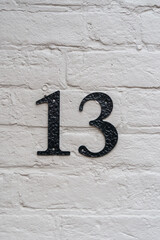 White brick wall with a number thirteen in black