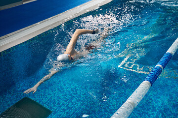Young male swimming in pool during workout
