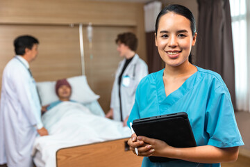 Young Asian woman in medical robe smiling and looking at camera during work against at clinic.Women...
