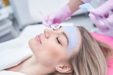 Fototapeta premium Calm spa client dozing during blue clay mask application