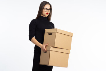 Getting fired. Dismissal, job loss, unemployment. Sad woman with boxes. A fired employee on a white background. Upset with dismissal woman in dark clothes.