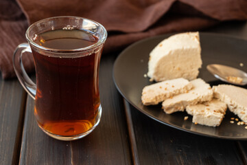 A glass of tea and tahini halva on a plate