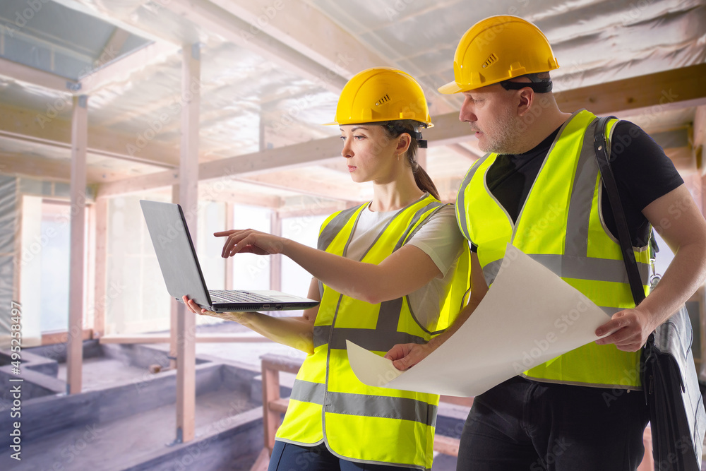 Poster man and woman in a house under construction. an architect and an engineer with a laptop. monitoring 