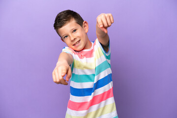 Little boy isolated on purple background pointing front with happy expression