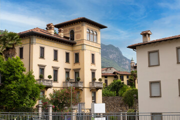 Fototapeta na wymiar Beautiful panorama of the old Italian town of Lovere with beautiful houses with tiled roofs against the backdrop of mountains on a sunny day.