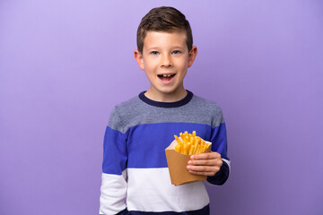 Little boy holding fried chips isolated on purple background with surprise facial expression