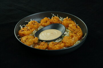 Fried squid or calamari rings with sauce.Fast food.  fried squids or octopus (calamari) with sauce - unhealthy foods