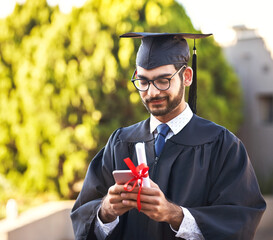 Posting his graduation speech online. Shot of a young man using a mobile phone on graduation day.
