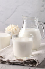 Fermented Drink Ayran in glass, milk in jug and curd in bowl on light gray background, Vertical format