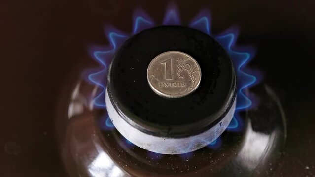 gas stove burner with russian ruble on top burning natural gas with blue flame