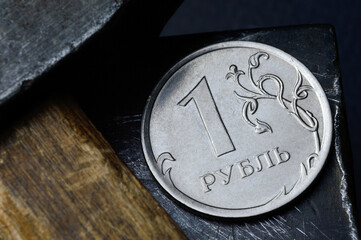 Russian coin with a face value of 1 ruble. and an old working tool. close-up. translation of the text on the coin "1 ruble"