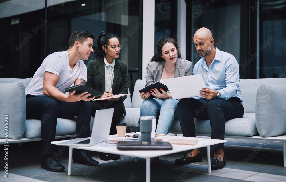 Poster an engaged team is a productive one. shot of a group of businesspeople using a digital tablet and la