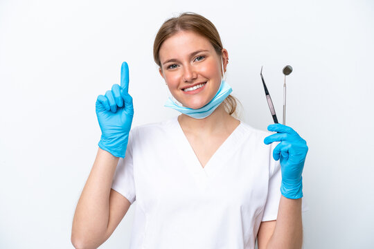 Dentist caucasian woman holding tools isolated on white background pointing up a great idea